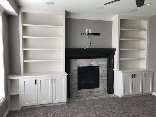 Built-in bookshelves beside a fireplace