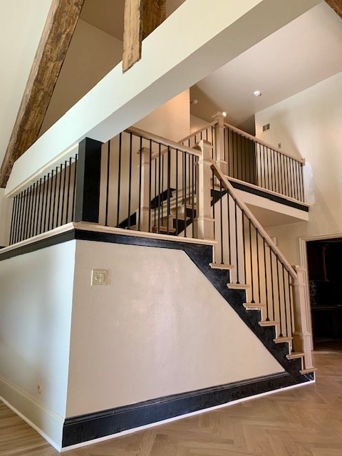 Open staircase and landing with iron balusters and oak rail