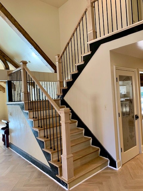 Two-story staircase with oak treads and iron balusters